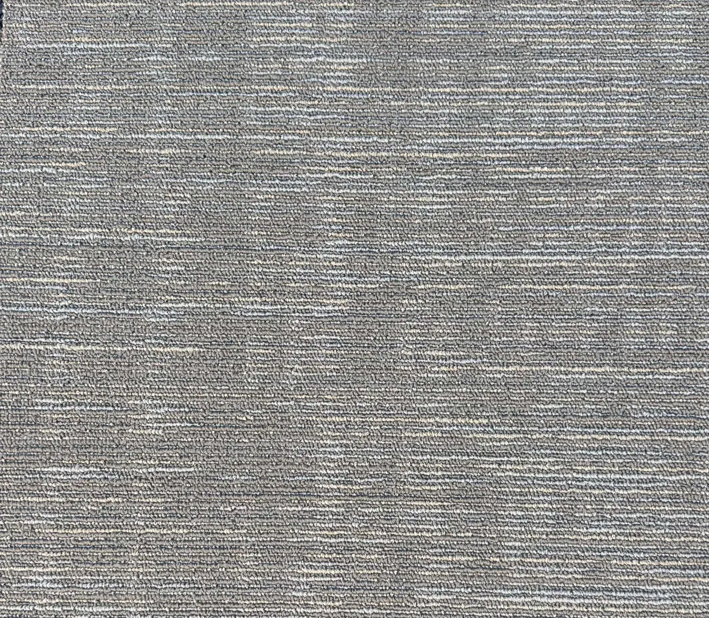 Grey textured carpet tiles laid on a floor