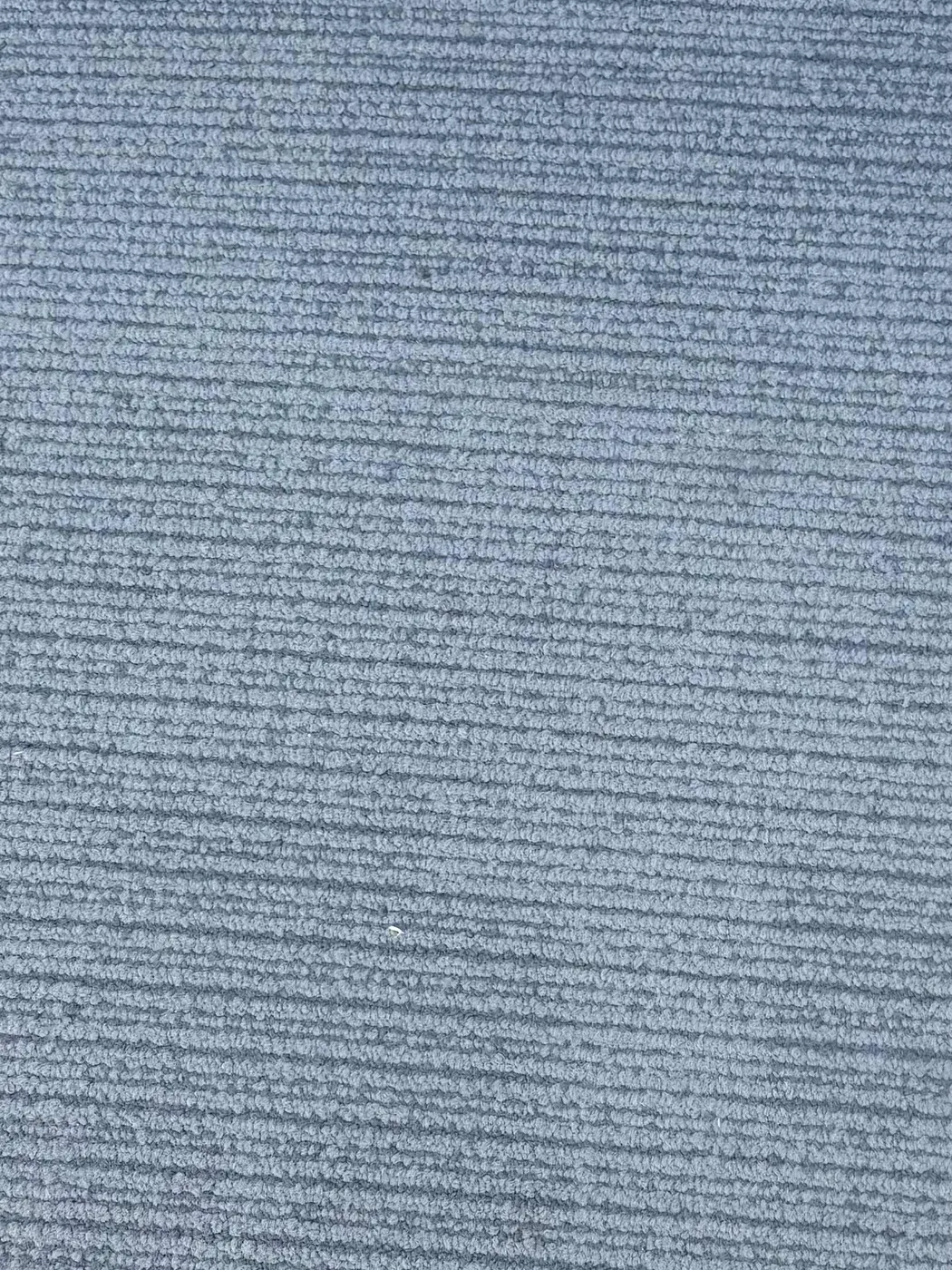 Single blue carpet tile on gravel